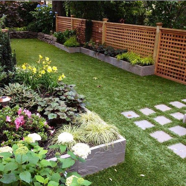 Grass in a Large Back Garden with Paving and Flowers